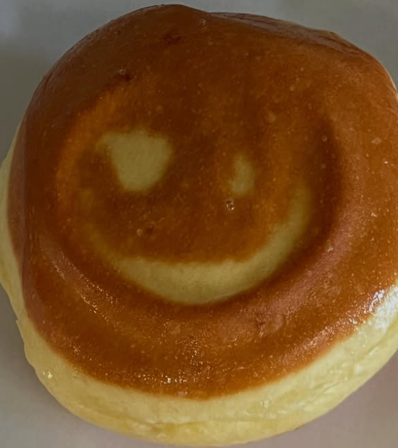 Un beignet doré marqué d’un sourire